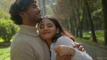 content famille Multi-éthnique couple les partenaires hispanique femme africain américain homme profiter romantique relation date. femelle fille Masculin garçon câlins toucher étreindre ensemble dans l'amour souriant en plein air dans parc video