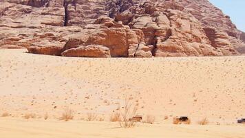 Static view red Wadi rum desert landscape with line of 4wd vehicles drive on valley desert. Sandy road on organized safari tour in Jordan video
