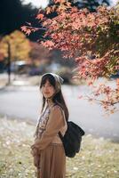 Casual dress elegance, Asian woman explores Kyoto's fall beauty, capturing cheerful smiles amid vibrant foliage and the scenic allure of Japanese tradition during a holiday. photo