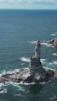 Top view of rocky cape landscape and lighthouse in sea. Clip. Fabulous landscape of rocky cape of island with abandoned lighthouse. Seascape with rocky cape and lighthouse on sunny day video