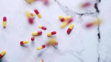 Tabletten fallen von das Himmel auf ein Marmor Oberfläche video