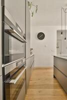 A modern kitchen with wooden floors and stainless steel appliances photo