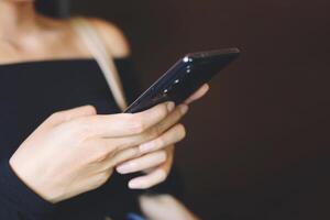 primer plano de una mujer joven que usa un teléfono móvil inteligente foto