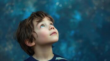 A young boy looking up at the sky with wonder and a hint of sadness as he thinks about the dreams he has yet to achieve photo
