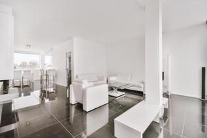 A clean white living room with a fireplace and a large window photo