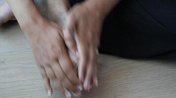 Hands Gently Performing a Deeply Relaxing Foot Massage on a Beautiful Wooden Floor video