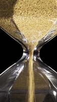 élégant et élégant bronze transparent sablier avec ruisselant d'or rond particules. Stock images. sablier isolé sur noir arrière-plan, temps, se dépêcher en haut, dernier minute, non temps concepts. video