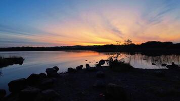 hermosa orilla del lago puesta de sol escenario, rocoso apuntalar a bola quirke lago, condado galway, Irlanda, naturaleza y paisaje, 4k video
