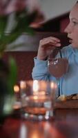 Aperto bocca impaurito Guarda sorpreso giovane adolescenziale ragazza con grande sorpresa Aperto bocca sembra lontano nel ristorante si agita cocktail candele fiori cena nel lusso Hotel video
