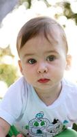 Beautiful little boy in summer clothes outdoors. Adorable toddler exploring the place outside. Close up. Low angle view. Vertical video