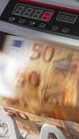 électronique en espèces compte machine compte cinquante euro billets de banque. Les figures en changeant rapidement sur le compteur afficher à toile de fond dans se brouiller. proche en haut. verticale video