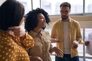 grupo de joven profesionales teniendo conversacion durante descanso en moderno oficina foto