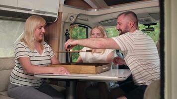 une famille de Trois pièces une planche Jeu séance dans une camping car video