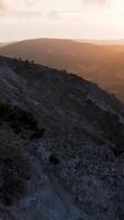 un' uomo è in piedi su superiore di un' collina a tramonto video