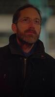 une réfléchi et contemplatif homme trouve lui-même dans une vibrant la nuit Urbain environnement video