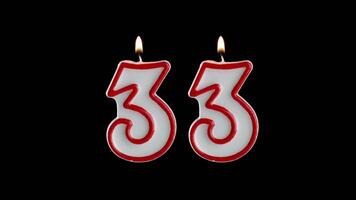 Candle in the shape of the number thirty three on a black background video