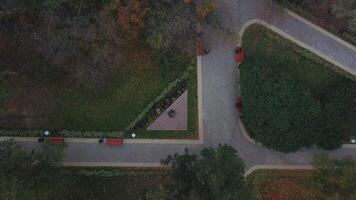 Top view of pedestrian park paths. Clip. People walk along paved flat paths in park in autumn. Intersecting paths with people walking in park on cloudy autumn day video
