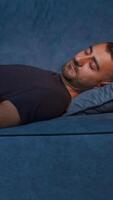em repouso cara. meios de comunicação. uma ampla confortável azul sofá e uma homem em repouso em isto quem dorme depois de uma Difícil dias trabalhar. video