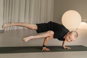 un niño practicas yoga poses adentro. para niños yoga foto