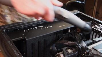passare l'aspirapolvere polvere a partire dal nero metallo pc Astuccio e più fresco griglia. uomo mano detiene vuoto addetto alle pulizie tubo con spazzola e pulisce computer hardware. personale computer Manutenzione. Odessa, Ucraina, 04 04 2021 video