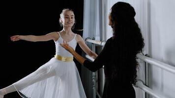 caucásico niña adolescente estudiante bailarina en tutu haciendo bailando ejercicios cerca ballet barra escuchando a explicaciones Consejo desde adulto profesor hembra entrenador ensayando coreografía danza educación foto
