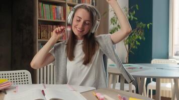 Happy Caucasian woman headphones earphones listening music female girl businesswoman university student audio song sound learning study joy smiling dancing indoor school business break library college video