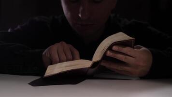 sacerdote leyendo un religioso libro en un oscuro habitación video
