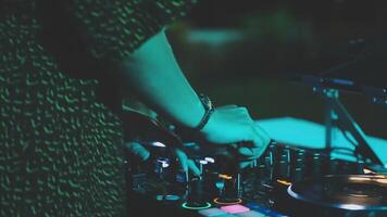 DJ work in a nightclub, mixing and dancing. A club DJ mixes music using an audio mixer and turntables on stage. A disc jockey plays in a club at a party. video