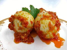 Egg Balado. Balado is a type of hot and spicy bumbu spice mixture found in Indonesian cuisine. Balado sauce is made by stir frying ground red hot chili pepper with other spices photo