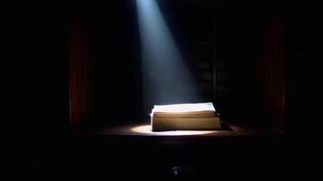 une livre illuminé par une Célibataire projecteur dans une foncé chambre, création une spectaculaire et mystérieux effet video