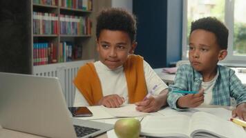 Little boys African American kids siblings pupils students children at school desk primary class online teaching call distant studying schoolboys e-learning internet laptop computer education video