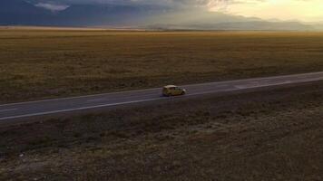 Steppe and desert. Aerial view of car journey through the mountains at sunset video