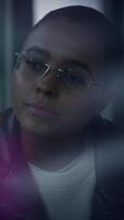un contemplativo individual vistiendo elegante lentes y un de moda cuero chaqueta, video