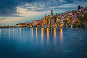 antiguo vistoso Mediterráneo playa edificios en menton a amanecer, Francia foto