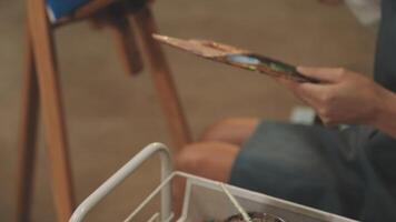 une femme est en portant une pinceau et La peinture sur une Toile video