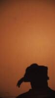 Silhouette of a dancer in motion against orange background video