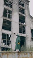 pessoa dentro radioativo zona. humano dentro químico protetora terno e mascarar caminhando em a fundo do destruído edifícios. biológico ataque. vertical video