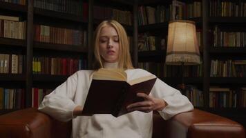 Woman reading a book in cozy library video