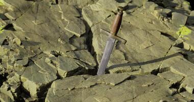Sword embedded in rugged rock formation at outdoor location video