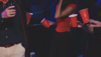 A group of people holding red cups at a party video