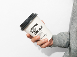 Paper cup on hand front view angle psd