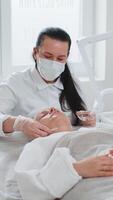 Cosmetologist applying special moisturizing acid serum peeling face chin of young woman in clinic video