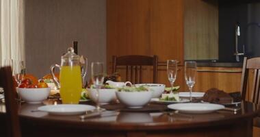 A table with a glass of orange juice and a bowl of salad video