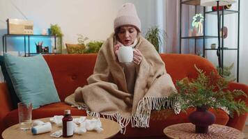 Sick ill woman suffering from cold or allergy sitting on home sofa sneezes wipes snot into napkin video