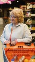 anziano donna la scelta frizzante bevande nel supermercato corridoio video