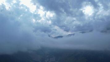 Aerial view of cloud-covered mountains and hidden valley below video