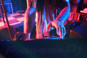 Unrecognizable DJ playing music in club photo