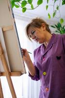 adulto mujer pintura lona a hogar foto