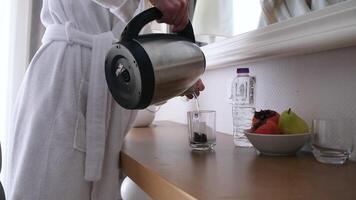 Frau Gießen heiß Wasser in das Tasse mit Tee Tasche, Frau Gießen heiß Wasser Herstellung Tee beim das Wohnung oder Hotel video