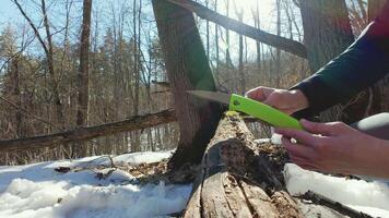A person cutting a piece of wood with a green knife video